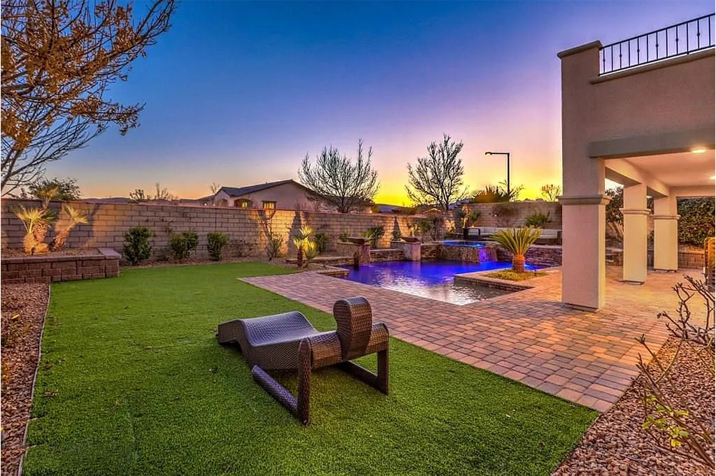 Backyard at sunset with pool and covered patio