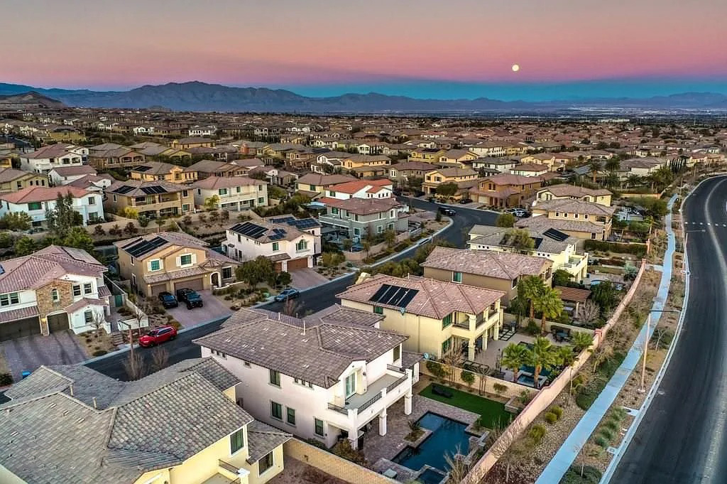 Aerial moonrise over neighborhood with mountain backdrop